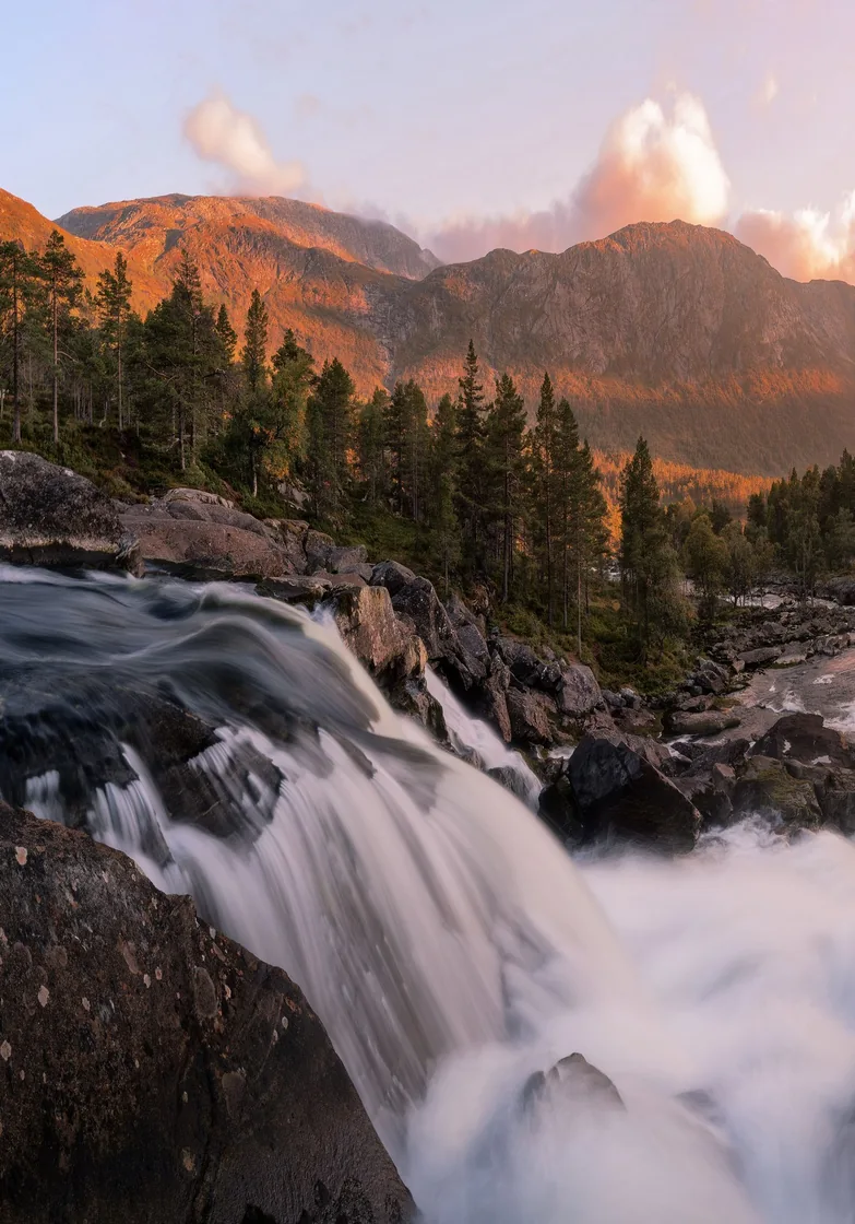 Water rushing over a rocky waterfall in a mountainous valley
