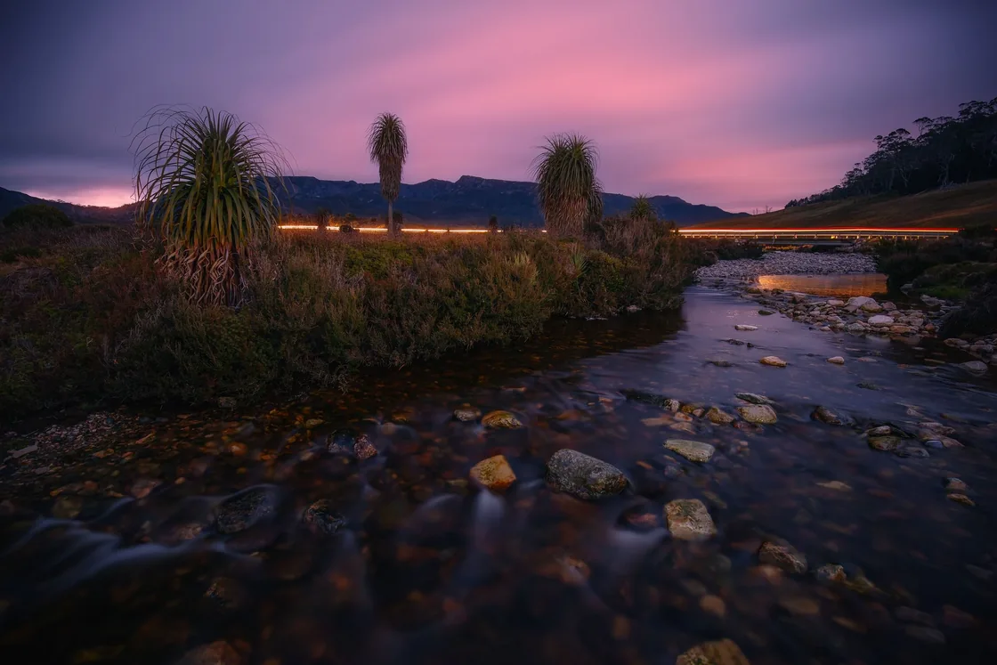 Pink and purple twilight over a flowing creek and button grass